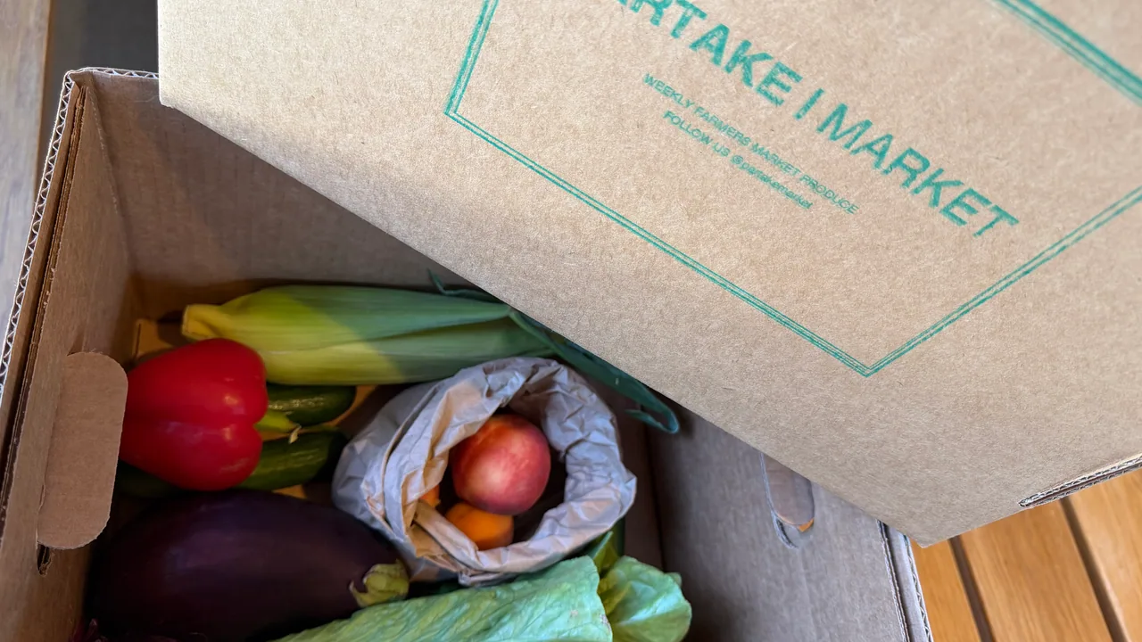 A freshly packed Partake Market produce box of seasonal fruits and vegetables.